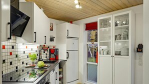 A modern kitchen with white cabinets, a black countertop, and a red coffee machine. - Awesome home in ørsted with WiFi (Ørsted)