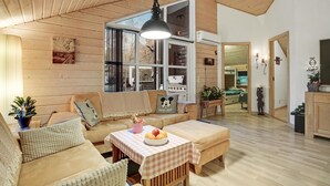 A cozy living room with a large window, a checkered table, and a sofa with a Mickey Mouse pillow. - Awesome home in ørsted with WiFi (Ørsted)