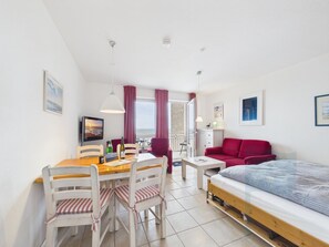 Un espace de vie compact comprenant un coin repas, un lit et un coin salon.