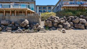 Ein Hotel direkt am Strand, mit modernem Design, einem markanten Balkon und Blick aufs Meer.