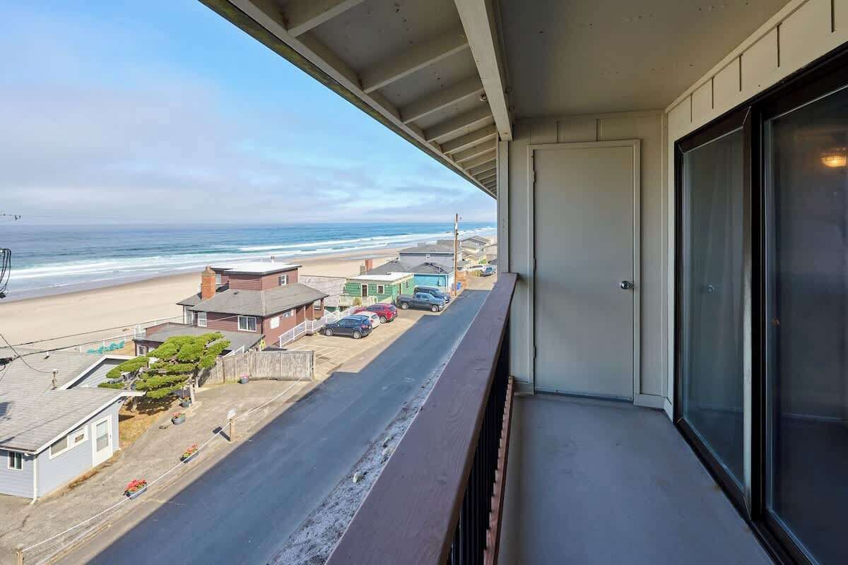 A balcony with a view of the beach and ocean.