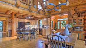 A spacious wooden cabin with a large kitchen, dining area, and a cozy living space.