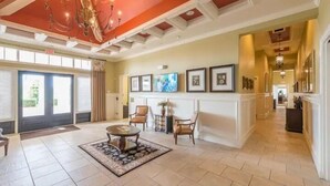 A spacious lobby with a high ceiling, a chandelier, and a large window with blinds. - Modern Pool Villa on Guard Gated Golf Community with Conservation Views (Davenport)