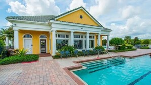 A building with a yellow facade, a swimming pool, and a covered patio area. - Modern Pool Villa on Guard Gated Golf Community with Conservation Views (Davenport)