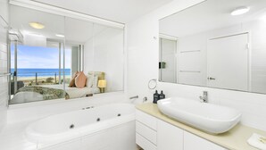 A modern bathroom with a large bathtub, a double sink, and a large mirror. - Kirra Beach 506 Pure Ocean Views (Coolangatta)