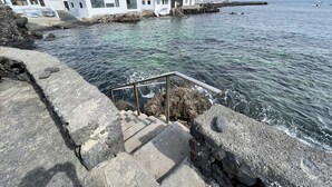 A coastal building with a stone staircase leading to a rocky shore. - Lanzahost Villa Mimosa (Punta Mujeres)