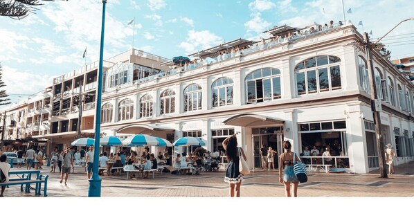 A hotel with outdoor seating and a covered patio area. - CG226 Coogee Bay Road, Coogee - Cozy Furnished Apartment Steps from Coogee Beach Cafes (Coogee)