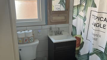 Tina con regadera, toallas, papel de baño