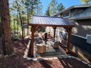 A covered patio area with outdoor furniture, a pergola, and a stone pathway. - Luxurious Tiny Cottage-Relax-Hike-Fish-Eat!! (Show Low)
