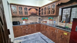 Eine Küche mit Holzausstattung, einem Gasherd, einer Spüle und einem Kühlschrank.