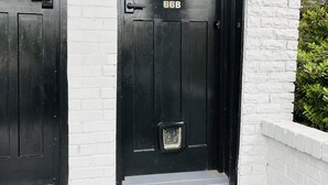 Une porte d’entrée noire avec un panneau de verre et le numéro 66B.