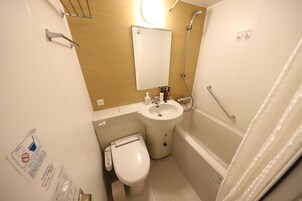 Une petite salle de bain comprenant des toilettes, un lavabo et une douche.