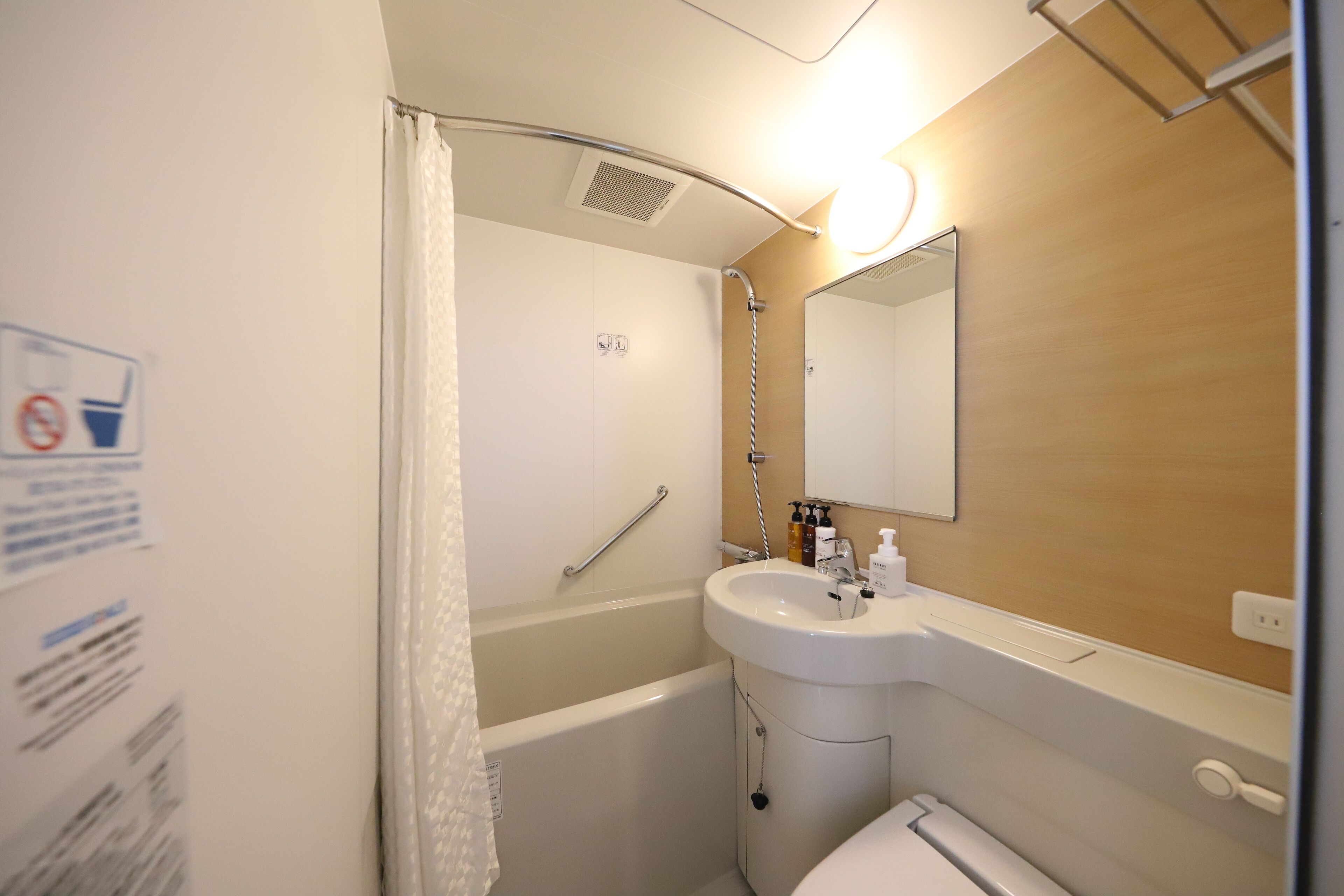 A bathroom with a bathtub, a sink, and a mirror.