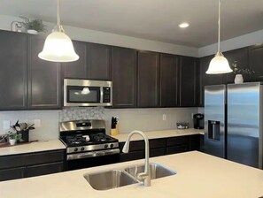 Enjoy cooking in this well-equipped kitchen with a stove, microwave, and refrigerator.