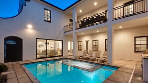 Un bâtiment à deux étages doté d’une piscine, d’un espace extérieur aménagé et d’un balcon avec du mobilier.