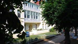 A building with a white facade, multiple windows, and a balcony with a metal railing. - Haus Wanda Appartement 4a - Haus Wanda (Heringsdorf)