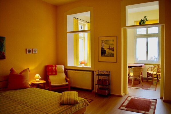 Une chambre confortable avec un lit, une chaise, une table et une fenêtre.