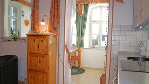 Eine Küche mit Holzausstattung, einem Spülbecken und einem Fenster mit Vorhängen.