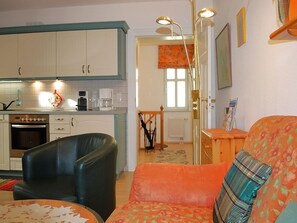 A compact living space with a kitchenette, a sofa, a dining table, and a chair. - Haus Bellevue Wohnung 10 - Haus Bellevue (Heringsdorf)