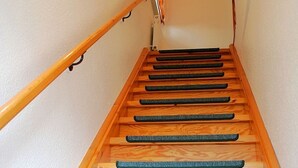 Eine Holztreppe mit Handlauf und Teppichstufen.