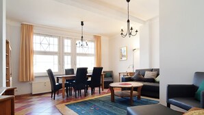 Una sala de estar bien iluminada con comedor, un sofá y una mesa de centro.