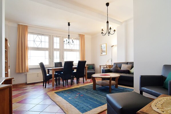 A well-lit living room with a dining area, a sofa, and a coffee table.