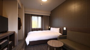 A hotel room with a large bed, a small round table, a sofa, a TV, and a window with curtains. - Dormy Inn Okayama (Okayama)
