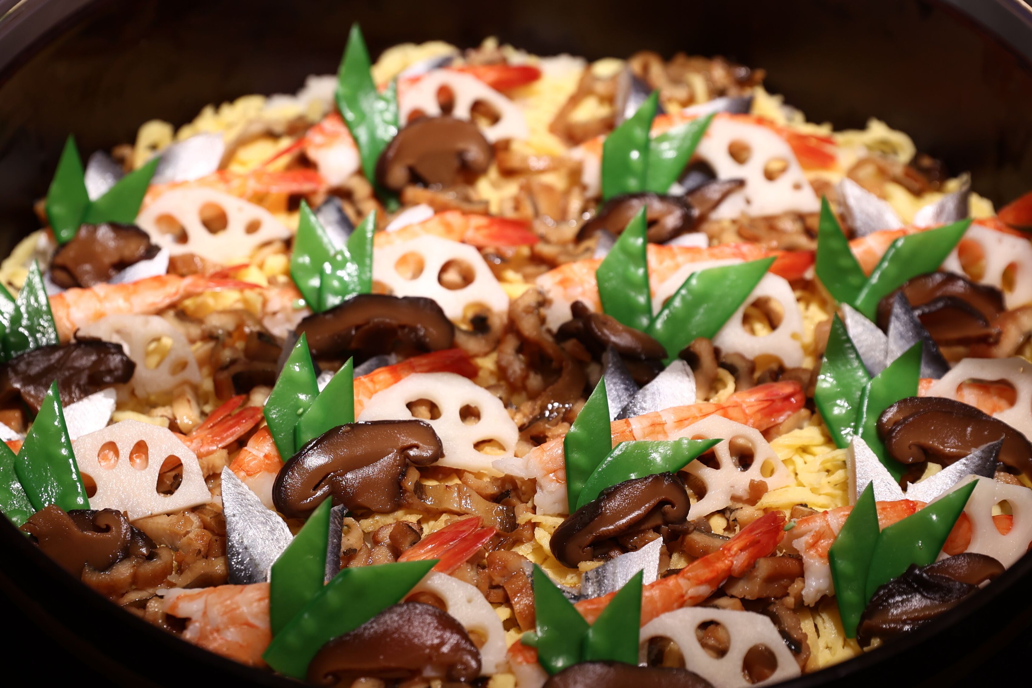 A close-up of a seafood paella dish with shrimp, mushrooms, and green leaves.