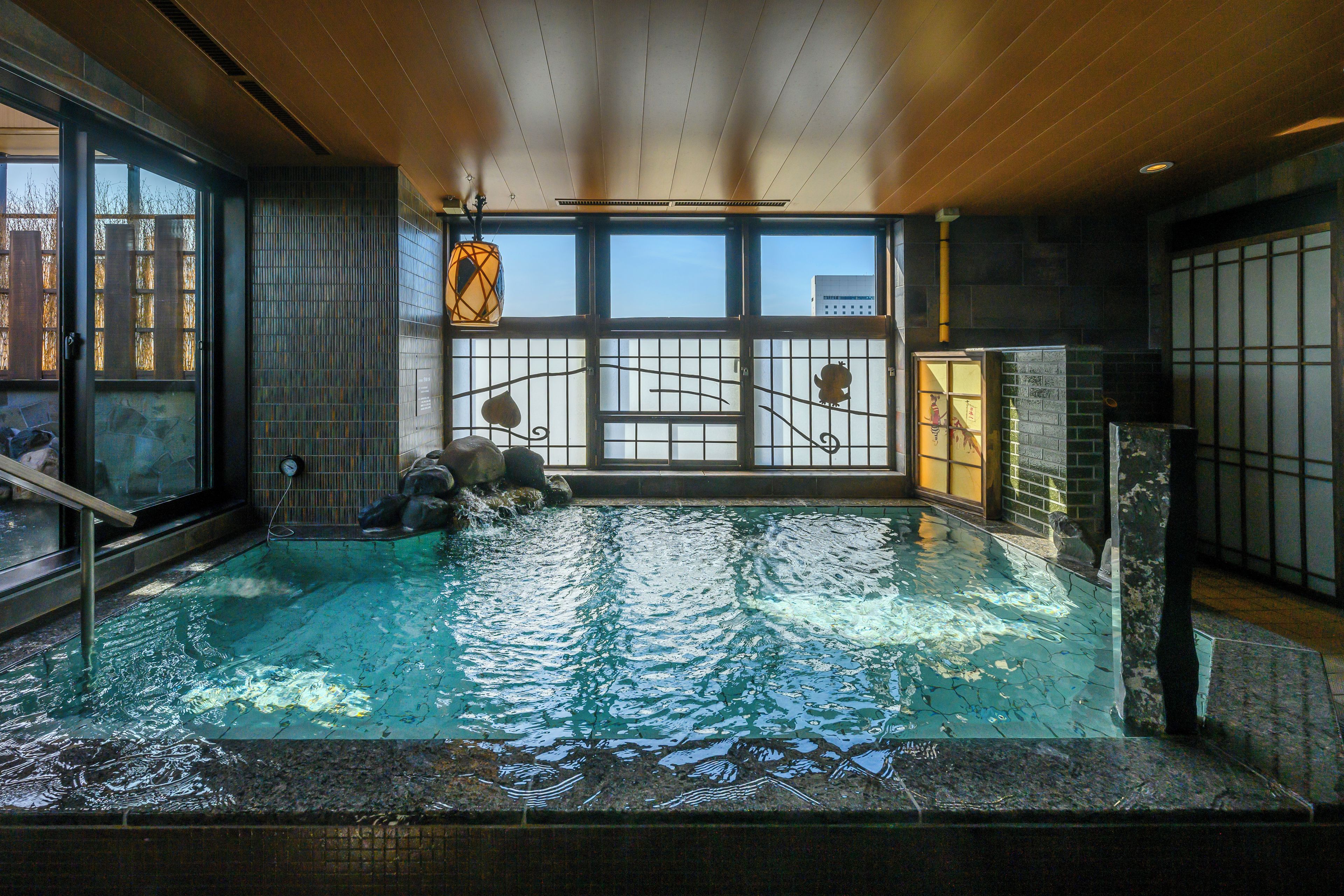 An indoor swimming pool with a view of the city skyline through large windows.