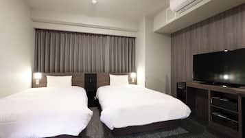 A hotel room with two single beds, a flat-screen TV, a built-in air conditioning unit, and a large window with curtains.
