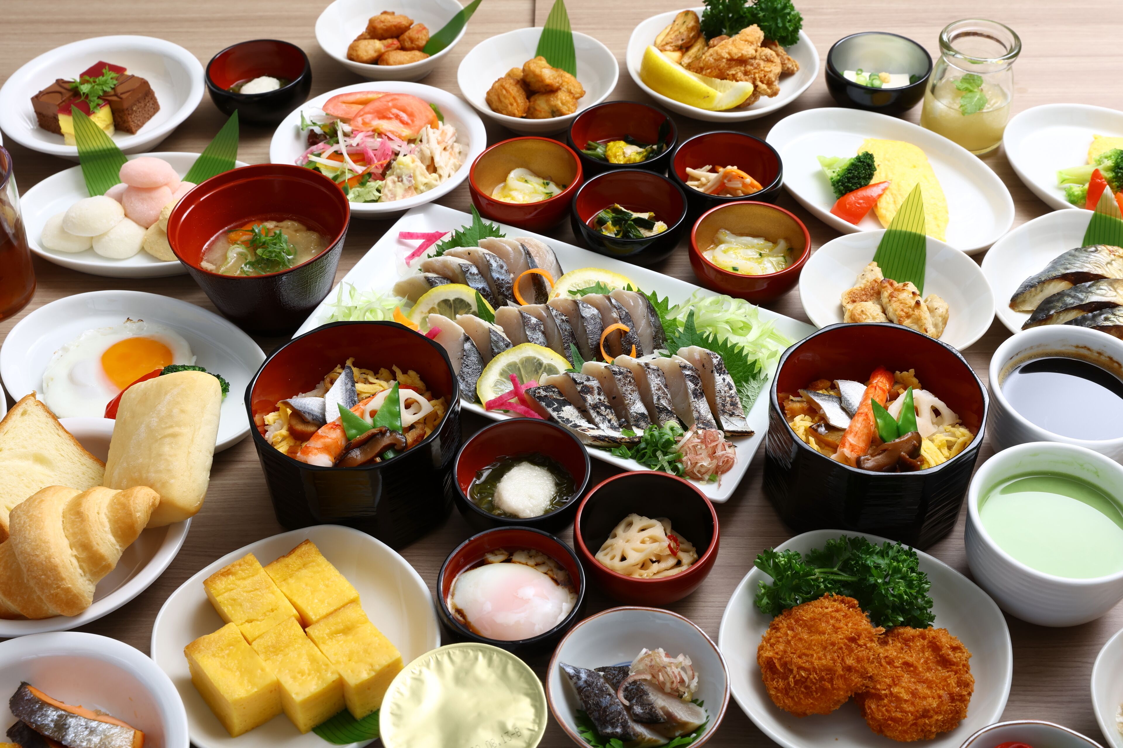 A variety of dishes arranged on a table, including sushi, sashimi, and other Asian cuisine.