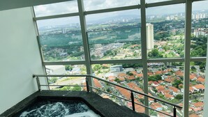 A hot tub with a city view through large windows. - Tri Tower By Antlerzone (Johor Bahru)