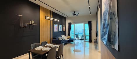 Una sala de estar moderna con comedor, ventanas amplias y vista a la ciudad.