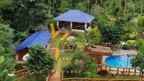 Un resort con piscina, gazebo e terrazza in legno.