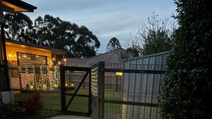 A pathway leading to a gated area with a house in the background. - Modern than 3 bedroom house  with office space in the center of Kallangur (Kallangur)