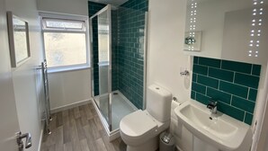 A modern bathroom with a glass shower enclosure, a toilet, and a sink. - Starfish Shack Apartment @ Sunnybeach (Paignton)