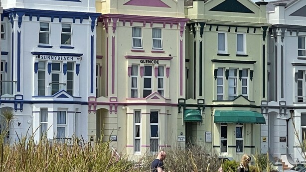 A row of colorful Victorian-style buildings with names 'Sunnybeach' and 'Glencoe' visible. - Starfish Shack Apartment @ Sunnybeach (Paignton)