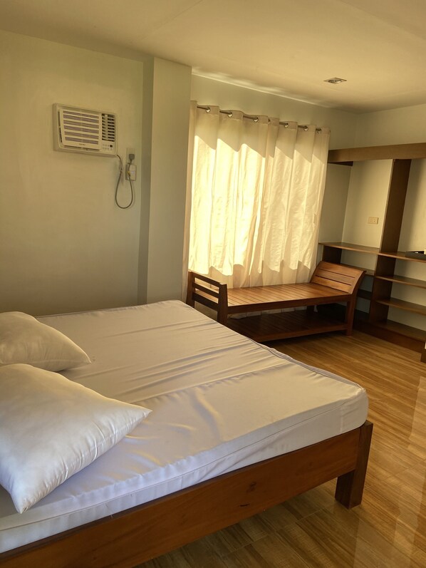 A bedroom with a wooden bed, a chair, a desk, and a wardrobe.