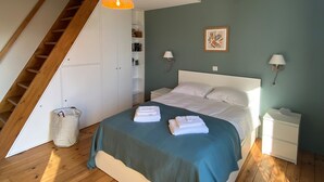 A bedroom with a bed, a nightstand, a lamp, a picture on the wall, and a staircase. - Comfortable (122m2) 1.2km from the beach (Jard-sur-Mer)