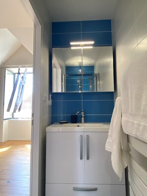A bathroom with a blue tiled wall, a white sink, and a mirror above it. - Cozy (122 m²) – 1.2 km from the beach (Jard-sur-Mer)