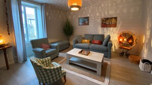 A modern living room with a sofa, armchair, coffee table, and decorative lighting. - Comfortable (122m2) 1.2km from the beach (Jard-sur-Mer)