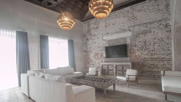 Una sala de estar con un sofá blanco, una mesita de centro y una chimenea.