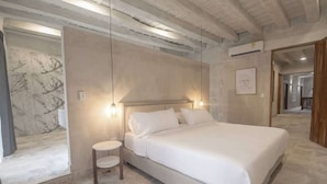 Un dormitorio con cama, mesita de noche y cabecero.