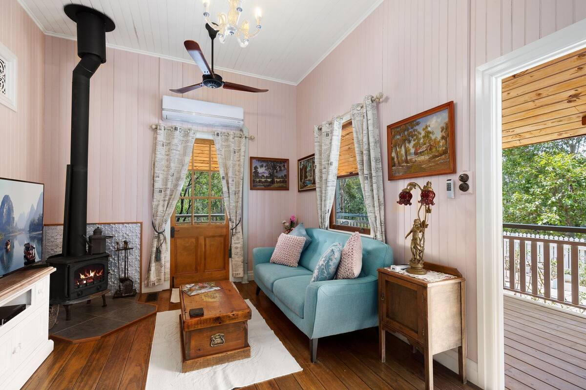 Una sala de estar acogedora con chimenea, un sofá azul y una mesa de centro de madera.
