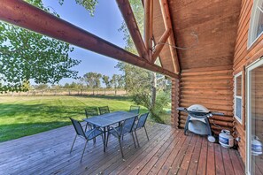 A wooden deck with a table and chairs, a grill, and a propane tank. - Serene Driggs Cabin ~ 10 Mi to Grand Targhee! (Driggs)