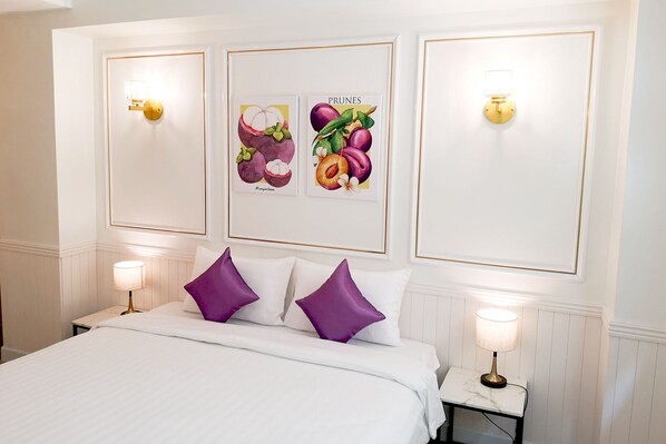 A hotel room with a bed, two nightstands, and wall-mounted lamps. - Rose Apple Hotel (Bangkok)