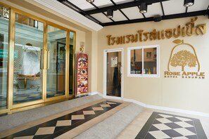 The entrance of Rose Apple Hotel in Bangkok with a modern design, including a glass door entrance and a tiled floor. - Rose Apple Hotel (Bangkok)