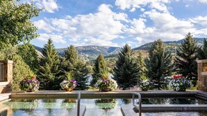 A pool with a view of mountains, surrounded by potted plants and trees. - Bel Lago #7 · Impeccable Lakeside Penthouse - Pool & Hot-Tub, A/C (Avon)