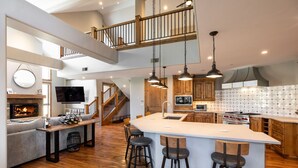 A spacious kitchen with a large island, wooden cabinets, and a built-in oven. - Bel Lago #7 · Impeccable Lakeside Penthouse - Pool & Hot-Tub, A/C (Avon)
