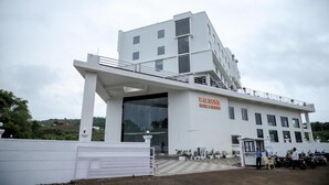 Um hotel moderno com uma ampla entrada de vidro e uma placa indicando 